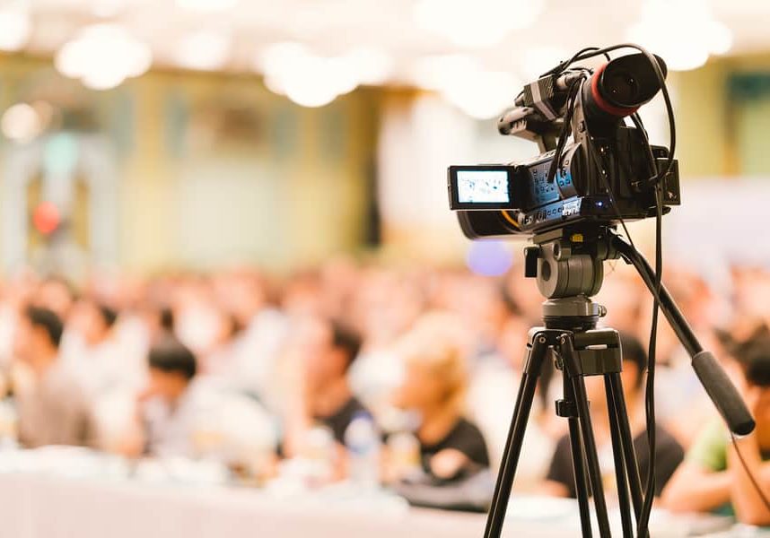 Video camera set record audience in conference hall seminar event. Company meeting, exhibition convention center, corporate announcement, public speaker, journalism industry, or news reporter concept